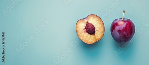 Red plum fruit Isolated on pastel background. Whole and a half of blue plum fruit. with copy space image. Place for adding text or design