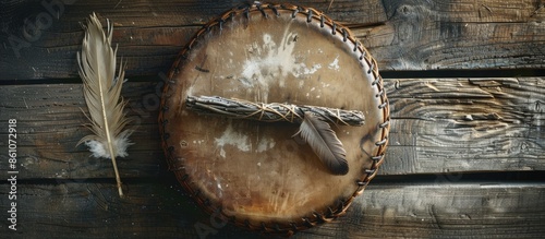 A top view image of a handmade leather meditation drum with sacred feather and sage smudge sticks. with copy space image. Place for adding text or design