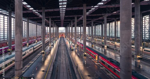 Atocha railway station platforms in Madrid during sunny day high Speed trains on the track. AVE, iryo, renfe, avlo, ouigo trans moving. Passenger traffic on the platform.
