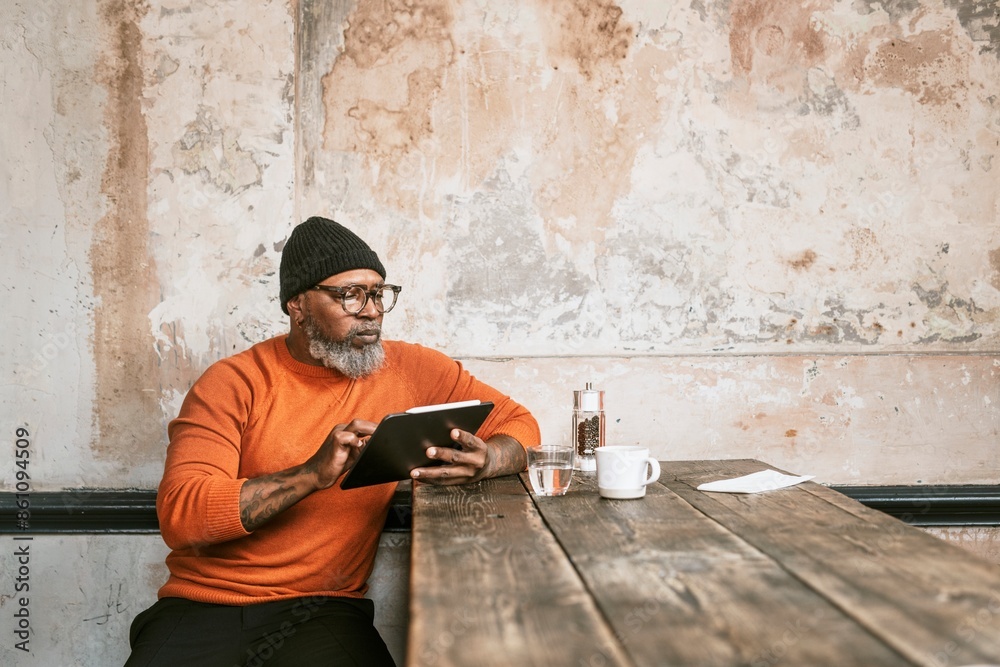 Fototapeta premium African American man using tablet at coffee shop