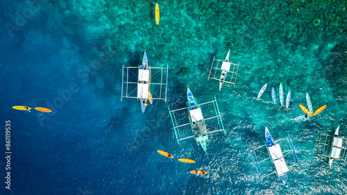 Top View from above  Bangka boat in front of a white sand beach bathed by a turquoise water. Coron Island, Palawan, Philippines. photo