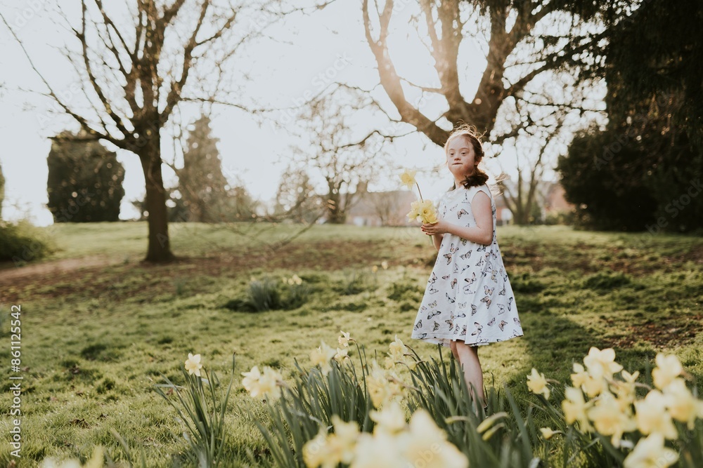Girl with Down Syndrome picking flowers in a park Girl with Down Syndrome picking flowers in a park