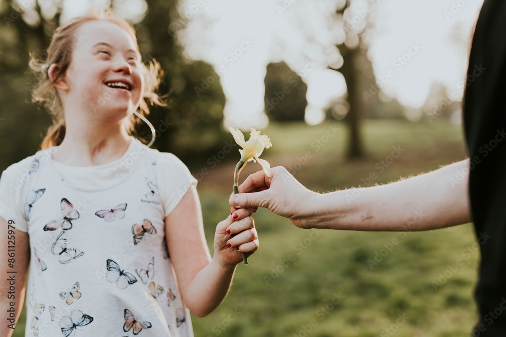 Fototapeta premium Down syndrome girl receiving flower