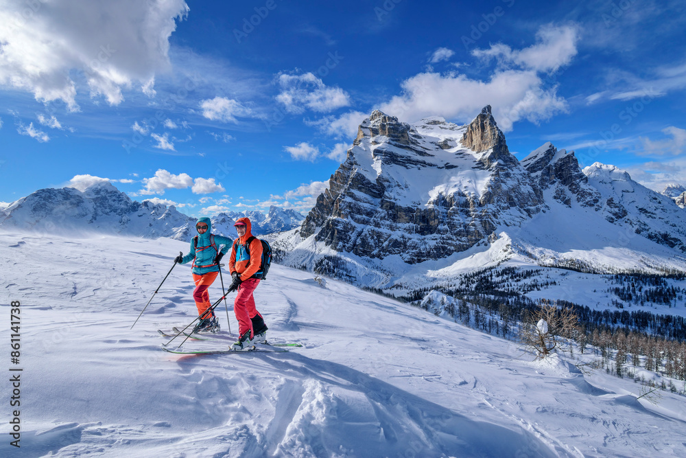 Couple hiking on snowcapped Dolomites mountains in Veneto, Italy