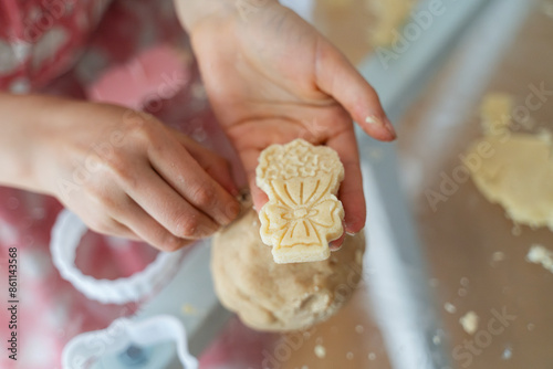 Girl's hand showing cookie at home photo