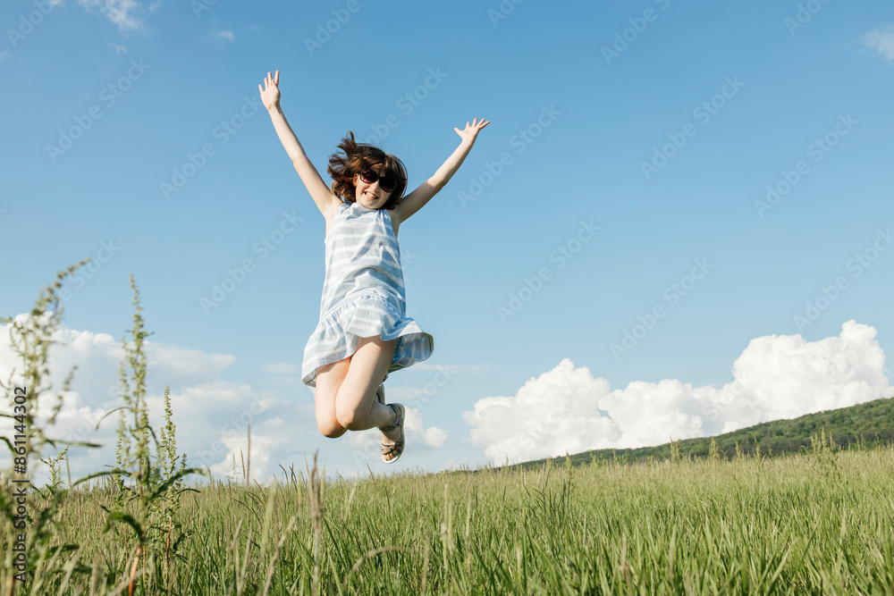 Young girl jumping in mid-air at field on sunny day Young girl jumping in mid-air at field on sunny day