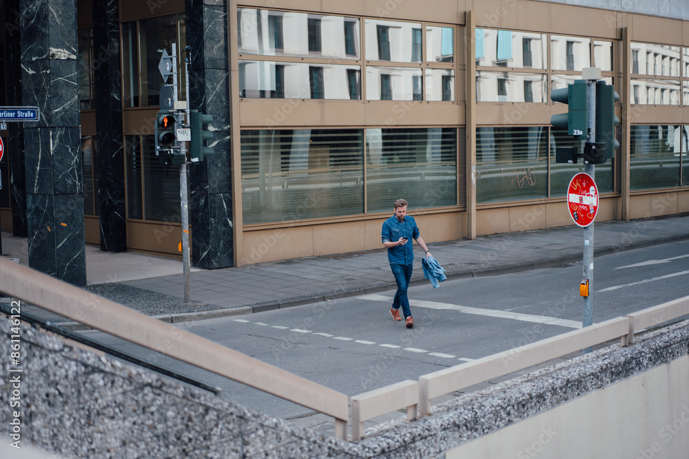 Businessman crossing road in front of building Businessman crossing road in front of building