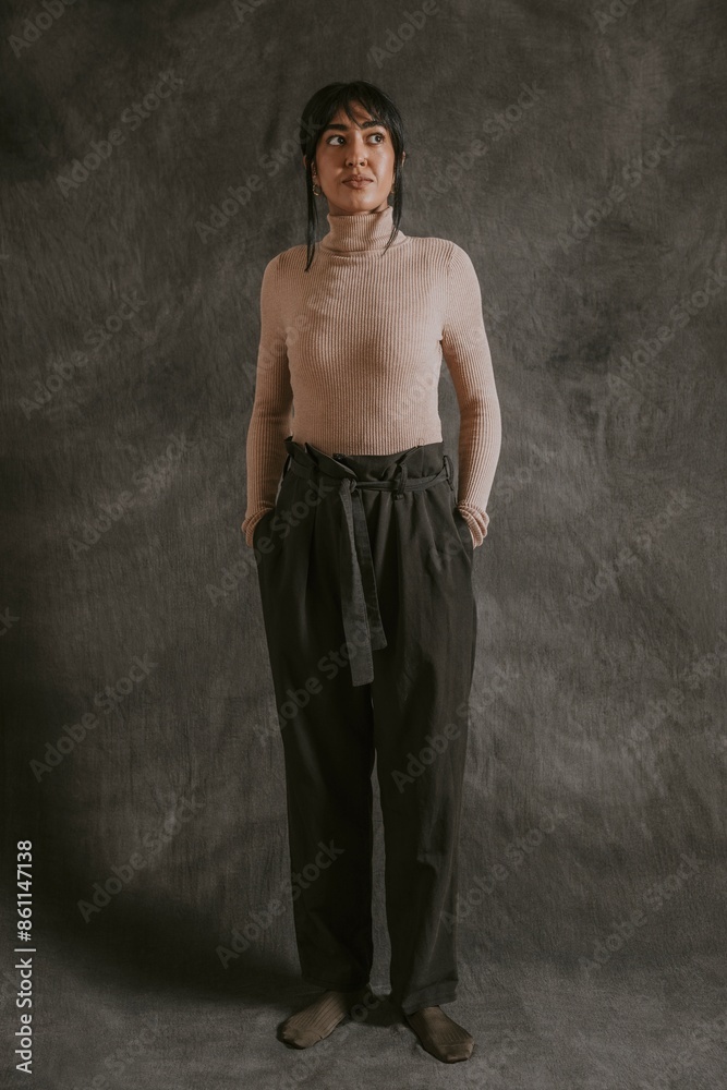 Woman in beige turtleneck sweater with black pants, autumn apparel fashion design Woman in beige turtleneck sweater with black pants, autumn apparel fashion design