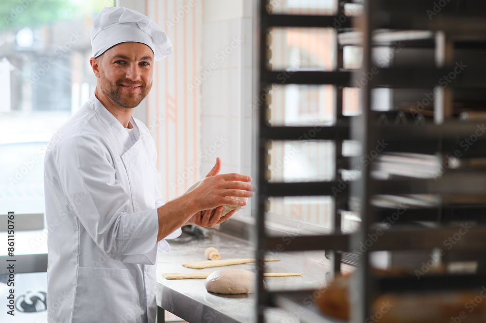 Baker kneading dough in a bakehouse or bakery Baker kneading dough in a bakehouse or bakery