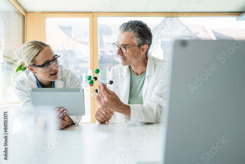 Scientists researching on molecule with tablet PC in laboratory