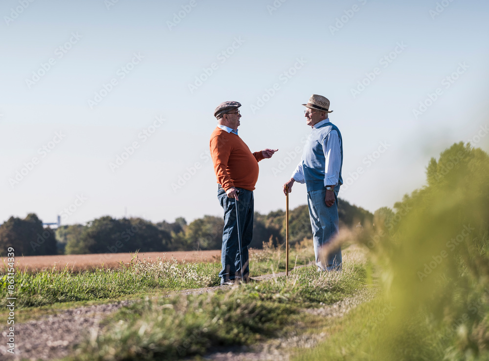 Friends talking in middle of dirt road at field Friends talking in middle of dirt road at field