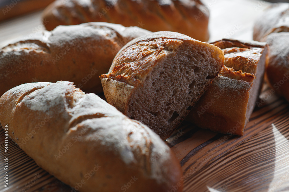 Freshly baked bread on bakery shelves. Bread diversity in bright light. Breads with a golden crust on wooden shelves Freshly baked bread on bakery shelves. Bread diversity in bright light. Breads with a golden crust on wooden shelves