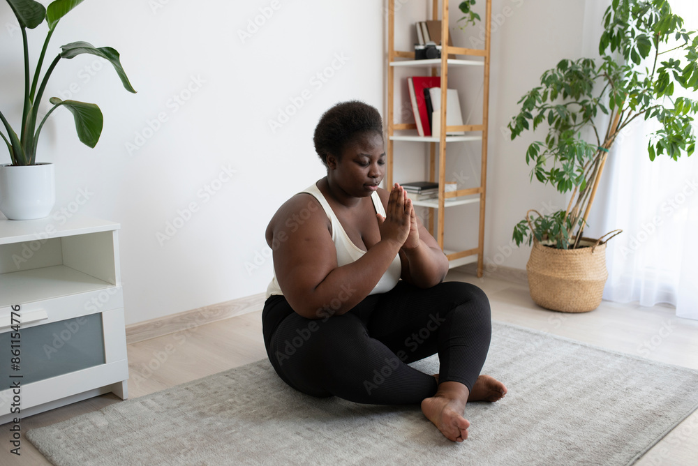 Young woman meditating on carpet in living room at home Young woman meditating on carpet in living room at home