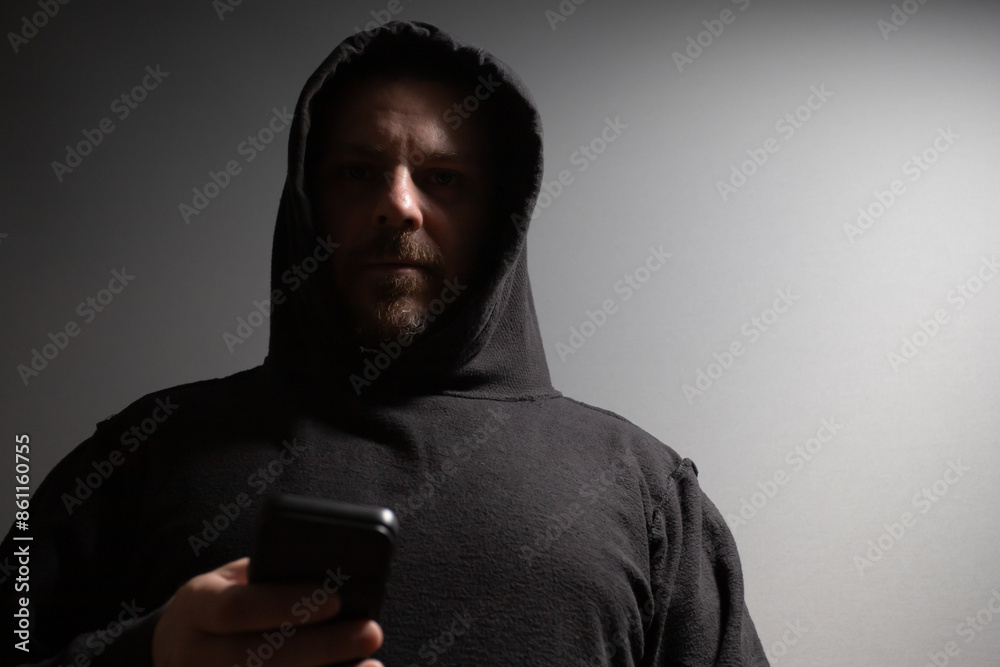 Identity thief, a man with a phone, stealing personal data, posing as a burglar, threatening security. Identity thief, a man with a phone, stealing personal data, posing as a burglar, threatening security.