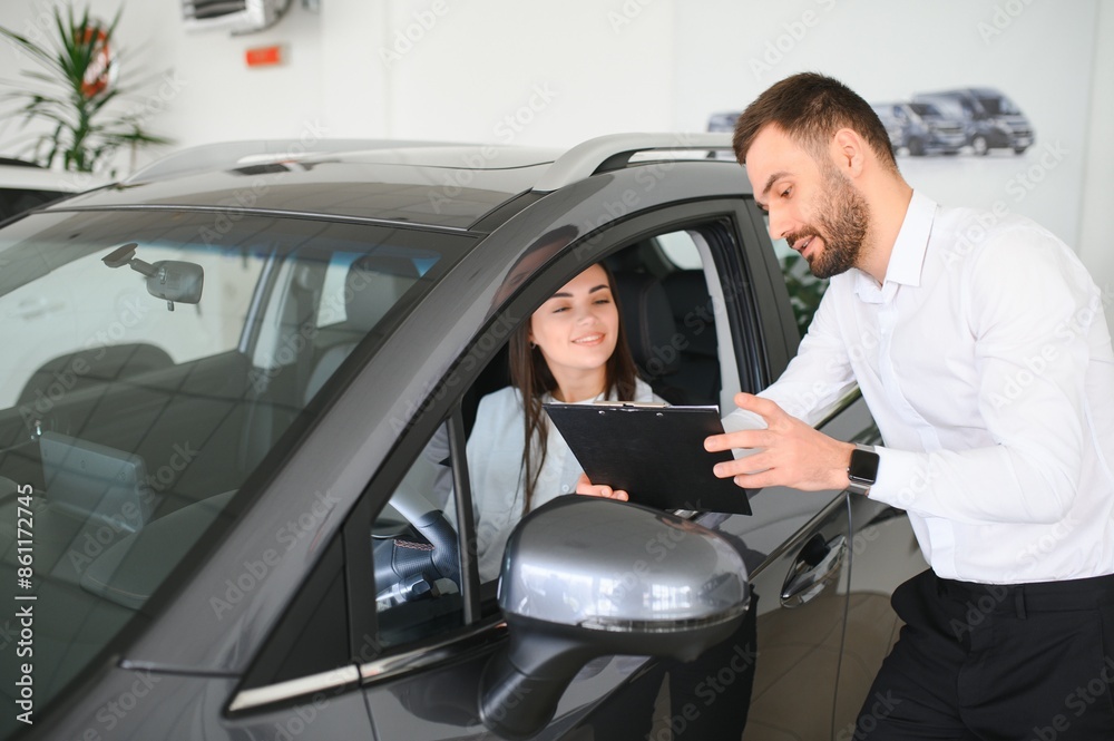 Car seller showing customer brand new car and talking about its performances Car seller showing customer brand new car and talking about its performances