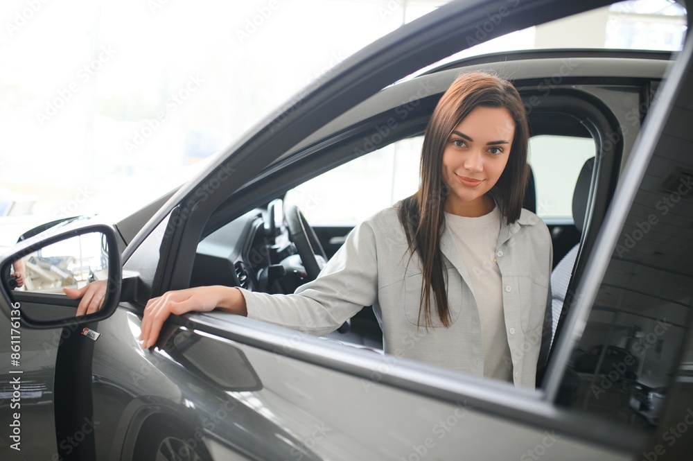 Beautiful young female client customer choosing new car Beautiful young female client customer choosing new car
