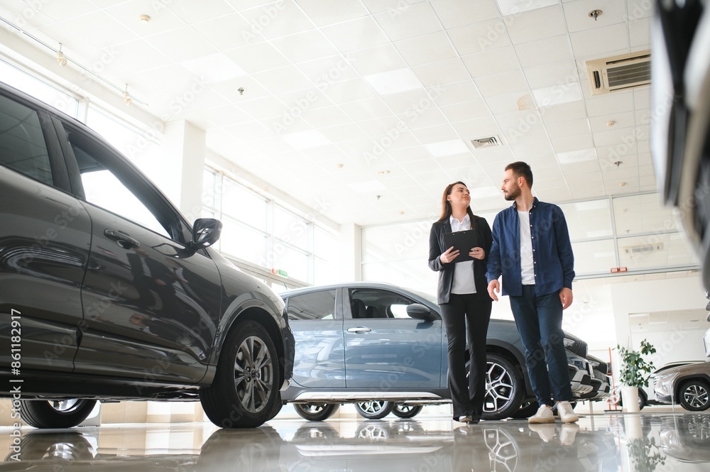 Professional salesperson selling cars at dealership to buyer Professional salesperson selling cars at dealership to buyer
