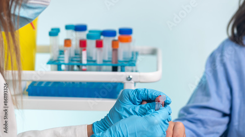 Cuadro en lienzo Nurse performs finger prick blood draw on patient for sample collection
