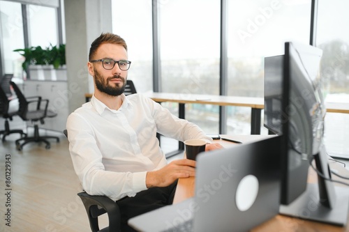 Financial Analysts and Day Traders Working on a Computers with Multi-Monitor Workstations with Real-Time Stocks, Commodities and Exchange Market Charts photo