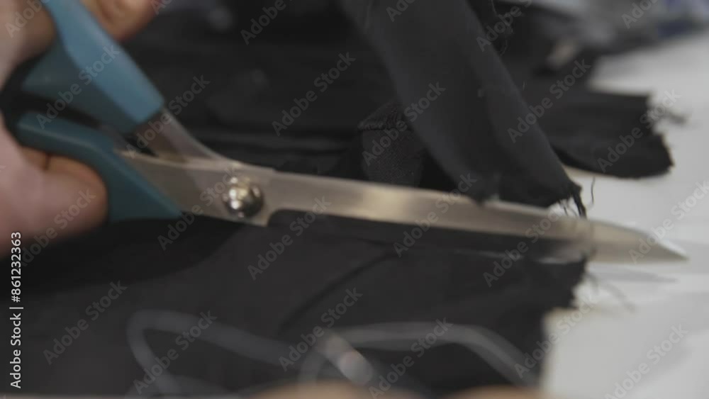 The tailor cuts the fabric with scissors The tailor cuts the fabric with scissors