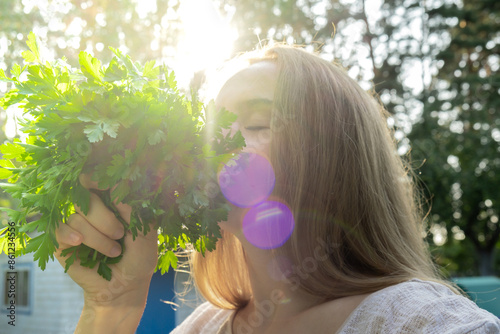 Farmer inhale parsley in garden open air. Organic home gardening and cultivation of greenery herbs concept. Locally grown fresh veggies