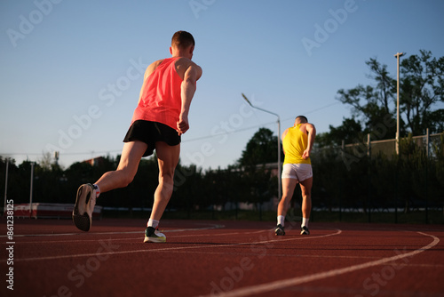 Two athletes compete in running at the stadium photo