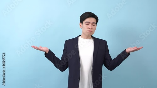 Young Asian businessman on blue background