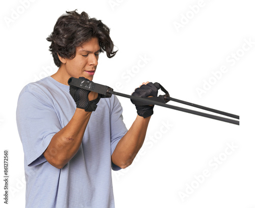 Young Latino man exercising with resistance bands in studio