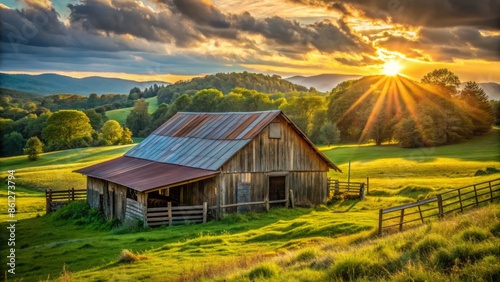Rustic rural landscape featuring old wooden cattle barn with metal roof amidst lush green pasture at golden hour sunlight.