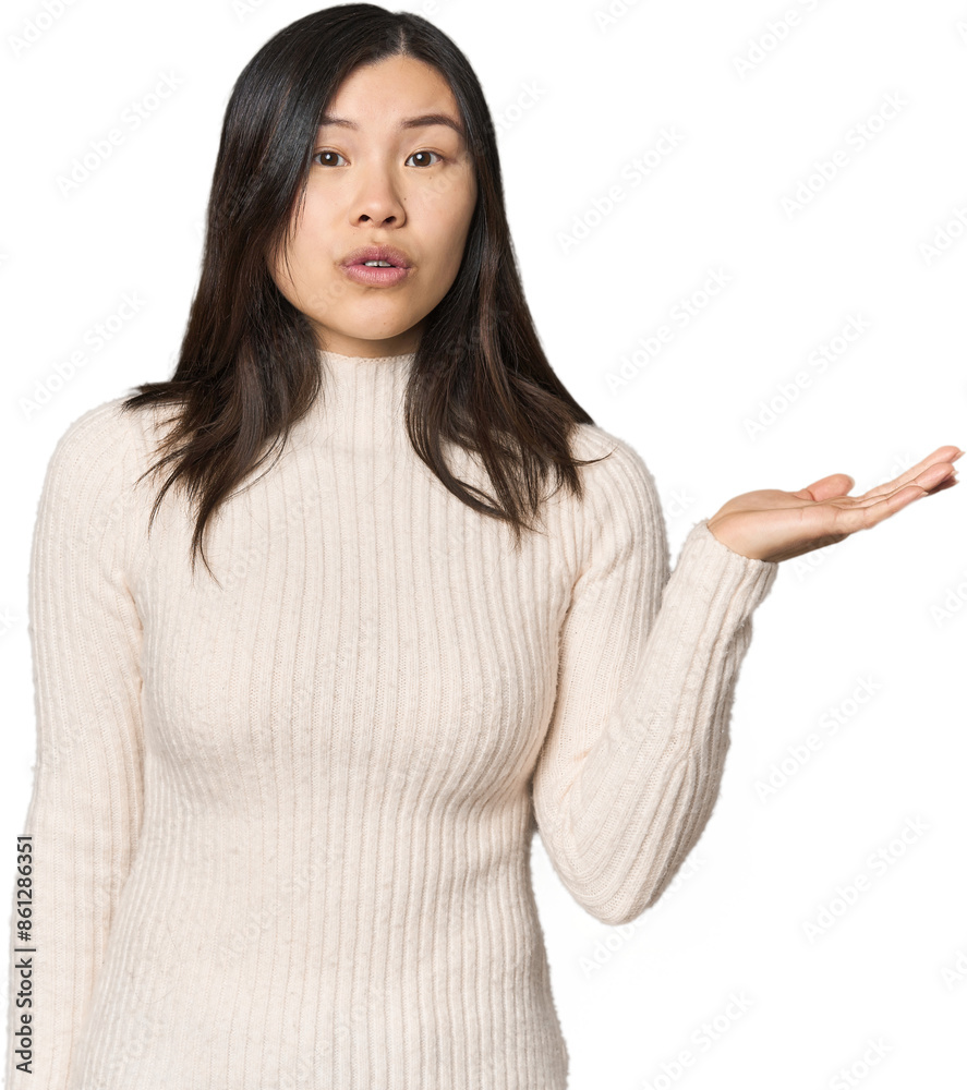 Young Chinese woman impressed holding copy space on palm. Young Chinese woman impressed holding copy space on palm.