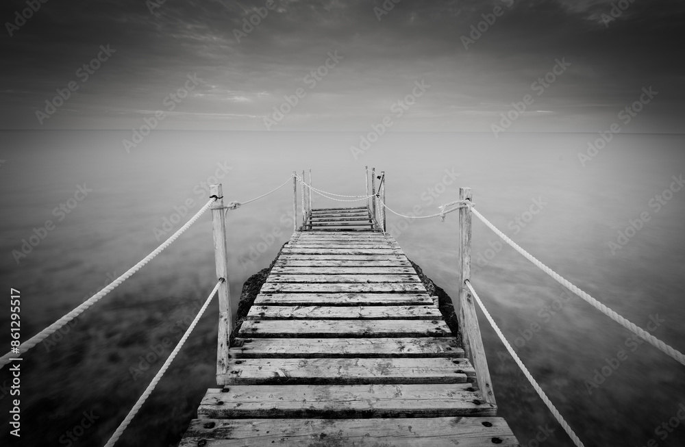 Long wooden pier in the sea at sunset. Long wooden pier in the sea at sunset.