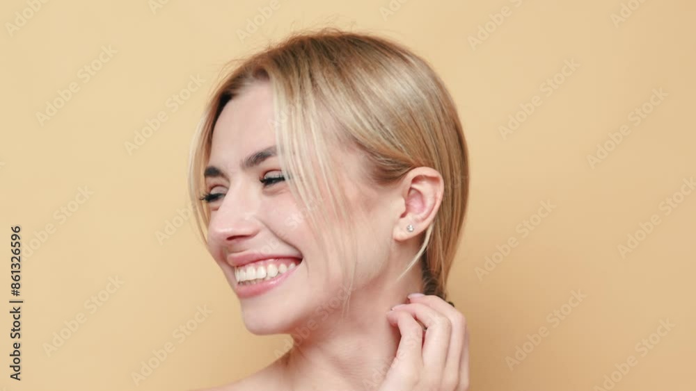 Beauty portrait of young happy optimistic beautiful blonde woman. Model posing with naked shoulders. Female isolated over beige wall background. Cheerful and happy. Cosmetology concept Beauty portrait of young happy optimistic beautiful blonde woman. Model posing with naked shoulders. Female isolated over beige wall background. Cheerful and happy. Cosmetology concept