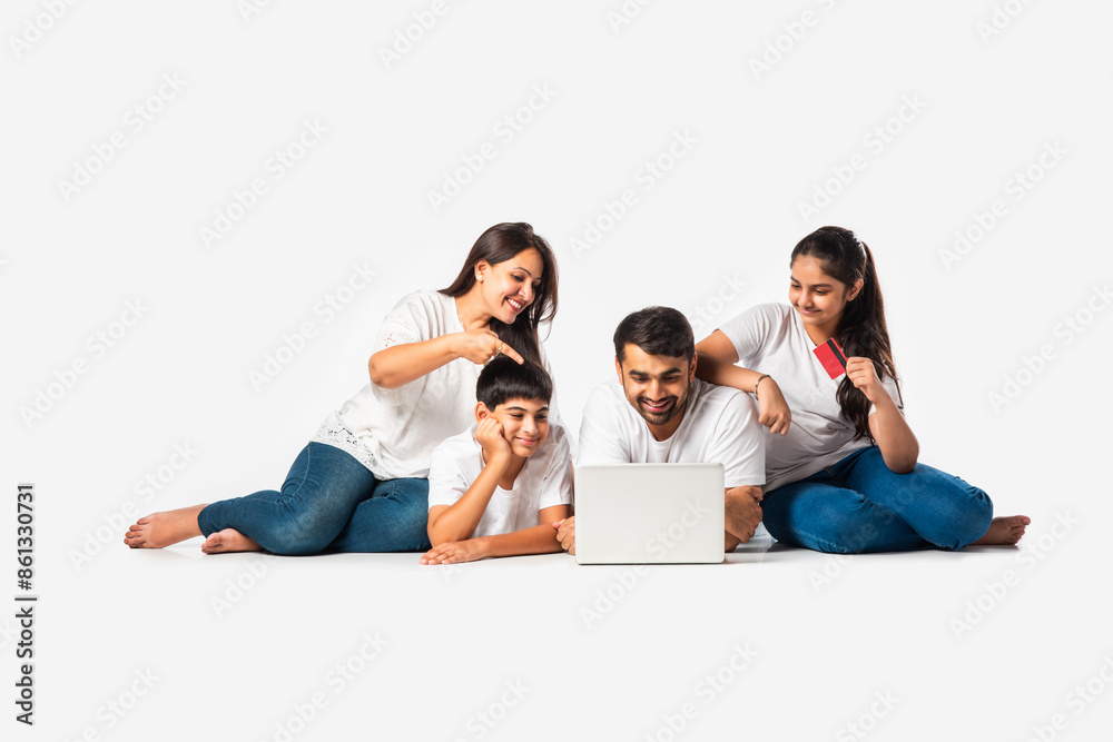 Indian asian young family with parents and kids using computer while sitting isolated on white Indian asian young family with parents and kids using computer while sitting isolated on white
