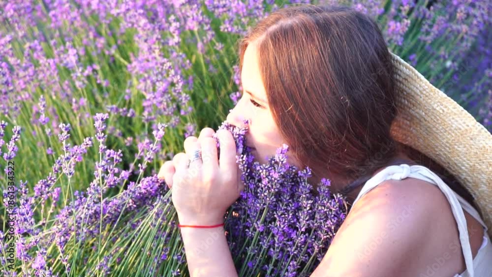 Woman in lavender field - Happy Lady in hat enjoys sunny day, wandering in lavender field, appreciating nature. Girl appreciates lavender bouquet fragrance, standing in field, on a clear day. Woman in lavender field - Happy Lady in hat enjoys sunny day, wandering in lavender field, appreciating nature. Girl appreciates lavender bouquet fragrance, standing in field, on a clear day.