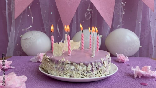 Happy birthday - light purple cake with burning candles and white with pink decorations, celebration concept