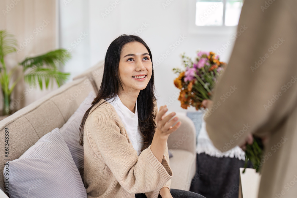 Happy Couple Enjoying Quality Time at Home with Flowers in a Modern Living Room Setting Happy Couple Enjoying Quality Time at Home with Flowers in a Modern Living Room Setting