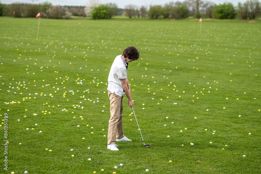 Fototapeta premium Dark-haired young guy training in a golf club