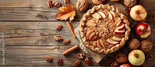 Delicious homemade whole wheat pie with apples, cinnamon, and a variety of nuts on a rustic wooden table with copy space image.