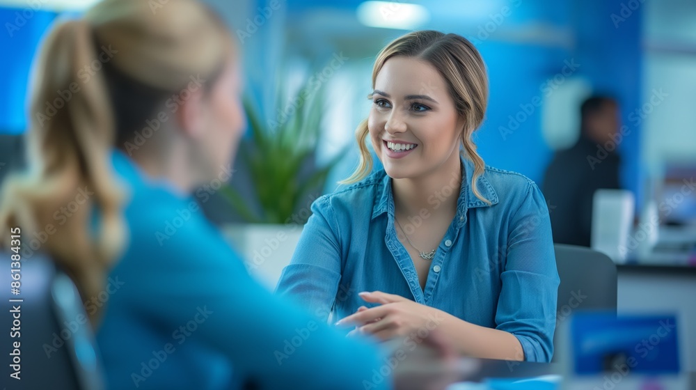 Two women in a professional office setting, engaging in a lively conversation, both smiling. Two women in a professional office setting, engaging in a lively conversation, both smiling.