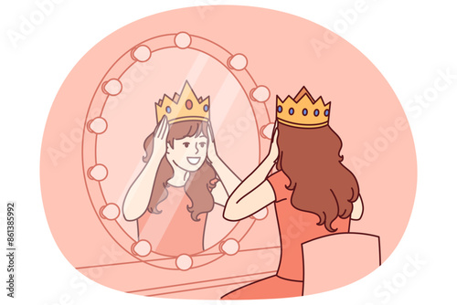 Little actress tries on crown sitting in dressing room with mirror and dreams of playing role of princess on theater stage. Teenage girl puts princess crown on head dreaming of living among kings