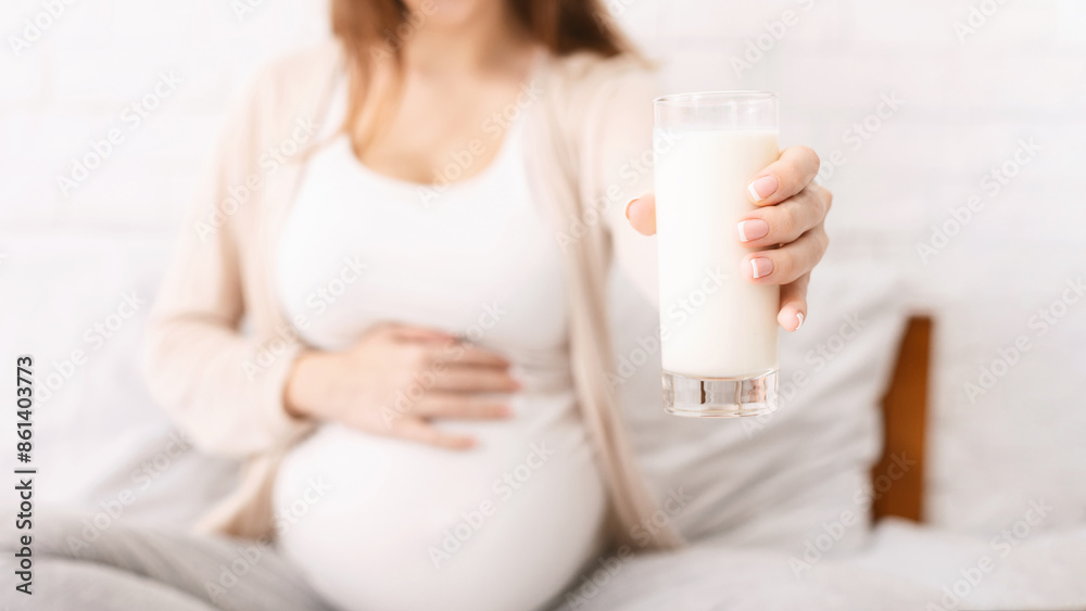 Lactation and breastfeeding concept. Pregnant woman offering glass with fresh milk on camera, conceptual photo Lactation and breastfeeding concept. Pregnant woman offering glass with fresh milk on camera, conceptual photo