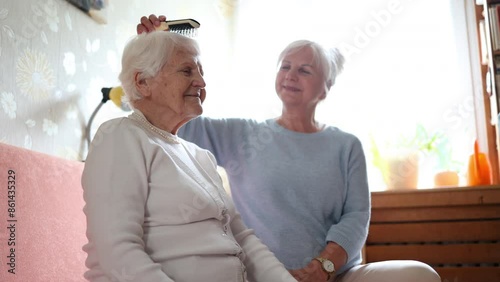 Caregiver combing the hair of an elderly woman in a nursing home
