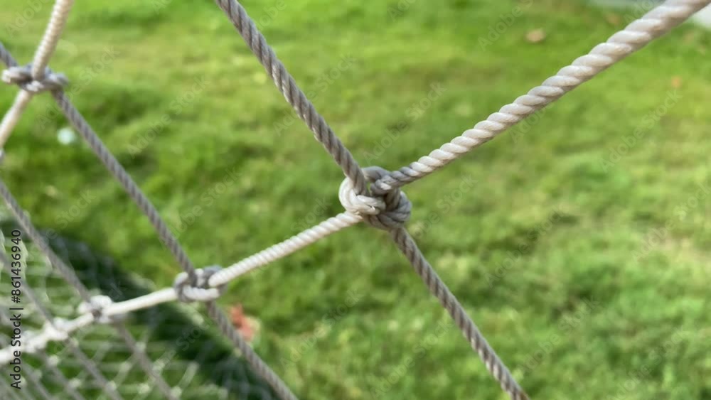 Football net goalie knotted white close up view outdoor sunny day with green grass on ground Football net goalie knotted white close up view outdoor sunny day with green grass on ground