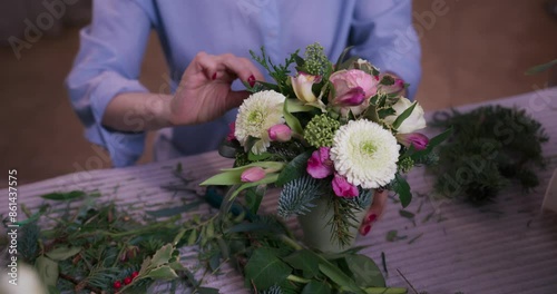Professional woman florist creates a bouquet in a flower studio.