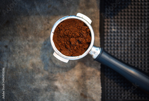 Top view of ground coffee in portafilter or portable coffee filter handle and ground coffee for a coffee making machine on coffee shop