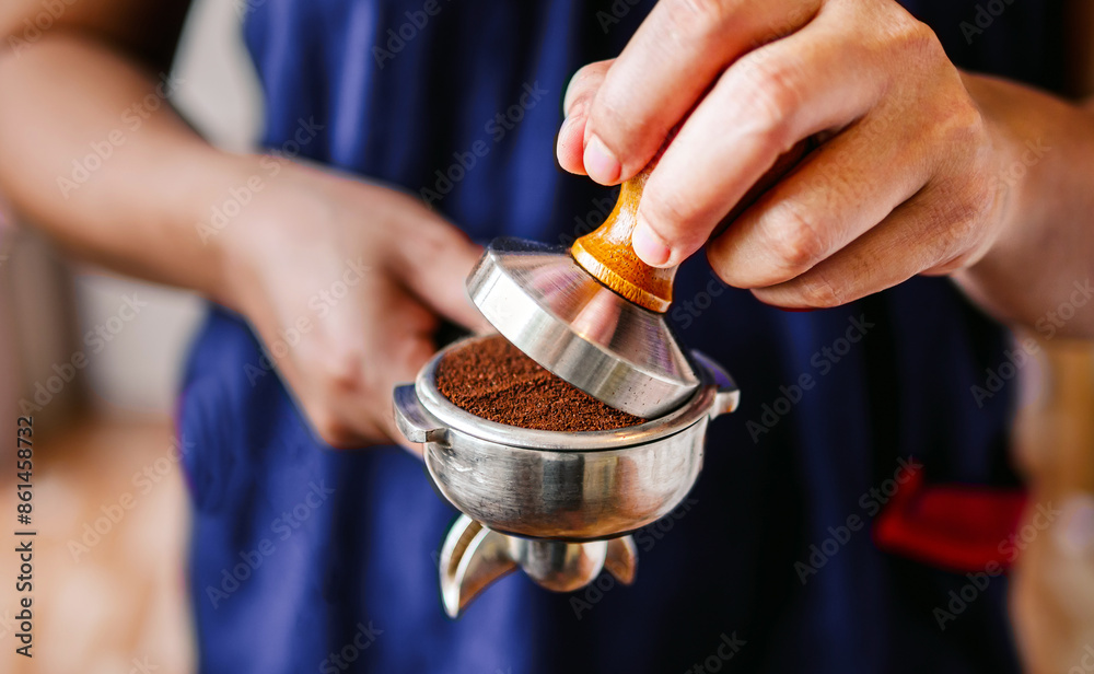 Close-up of hand Barista cafe making coffee with manual presses ground coffee using tamper at the coffee shop Close-up of hand Barista cafe making coffee with manual presses ground coffee using tamper at the coffee shop