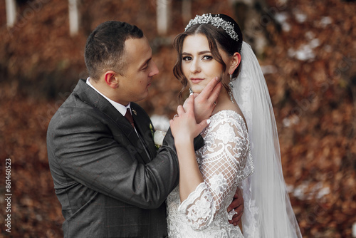 Φωτογραφία A bride and groom are posing for a picture in a forest