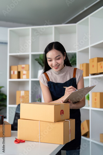 Young Entrepreneur Preparing Parcel Boxes for Online Ecommerce Business in Modern Office Setting