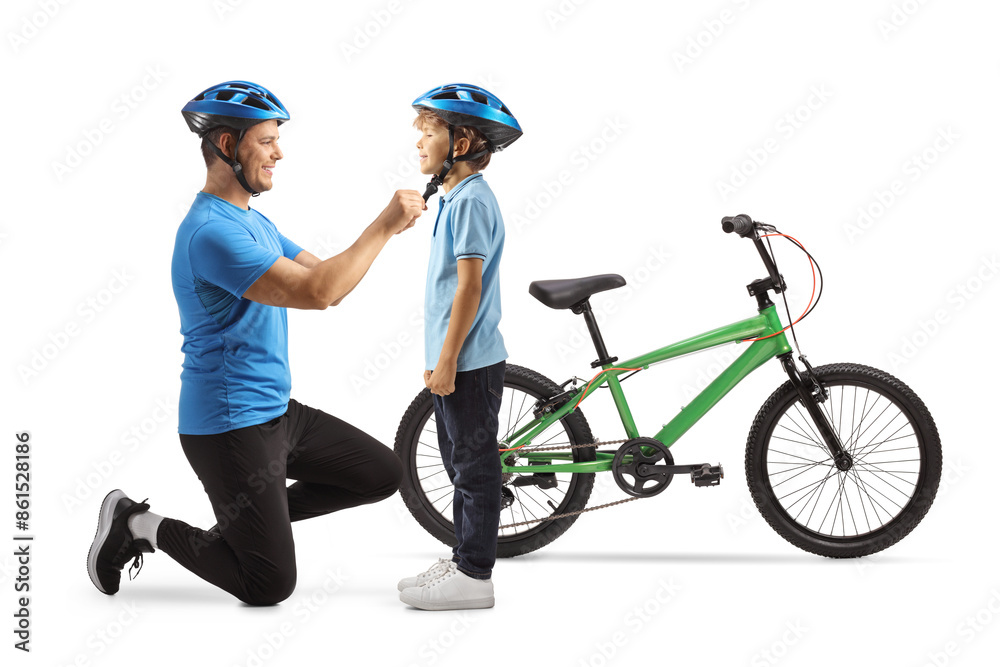 Naklejka premium Man putting on helmet on a boy for a bicycle ride