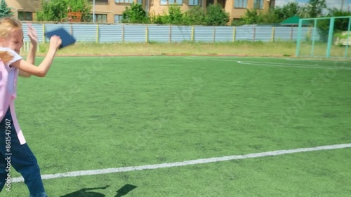 Elementary School girl enjoy and happy jumping on the field of playground after school class is over to retuning home photo